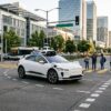 Automated vehicle driving through a city intersection near pedestrians and cyclists